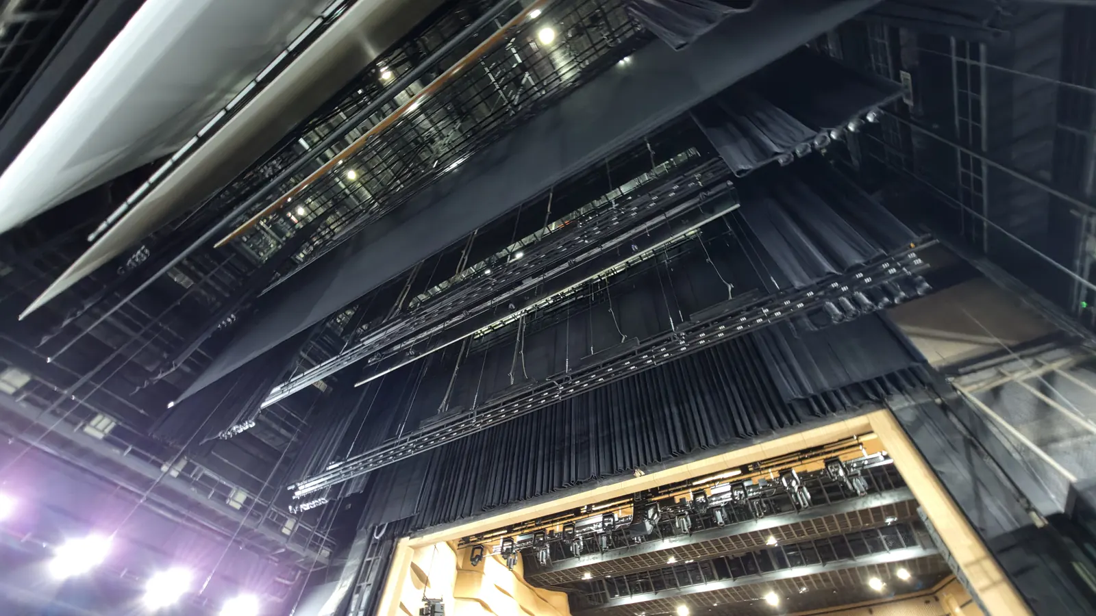 Looking up into the fly tower: battens, curtains and lighting battens hung in layers